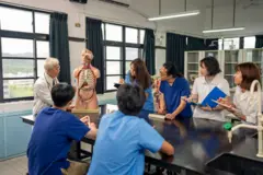 Un profesor asiático mayor y experimentado enseña anatomía humana utilizando modelos humanos y de órganos en el aula de anatomía.