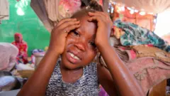 ابنة شقيقة الرشيد الطاهر، وهو رجل سوداني نازح، تبكي بعد سماعها قصة والدتها، بعد أن فرت العائلة من مدينة الفاشر التي مزقتها الحرب.