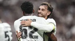 İki siyah beyazlı formalı oyuncu seviniyor. Biri siyah diğeri beyaz futbolcular bunlar.