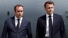 Лекорню та Макрон, обидвоє у темних костюмах, білих сорочках та темних краватках