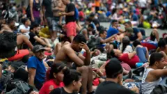 Migrantes esperan para entrar en territorio estadounidense.