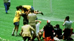 Jogadores brasileiros comemoram gol marcado na final da Copa do Mundo da Fifa de 1970 contra a Itália, atrás do gol italiano, observados pelos fotógrafos no campo de jogo