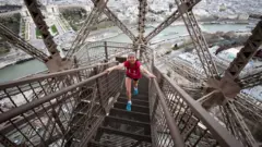 Persona subiendo los escalones de la Torre Eiffel.