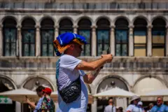 Un hombre cubierto por una tela mientras toma una foto en Italia