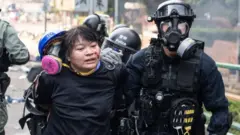 একজন বিক্ষোভকারীকে ধরে নিয়ে যাচ্ছে পুলিশ