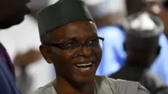 Embattled former Kaduna govnor Nasir El'Rufai dey laugh. E wear green traditional cap and agbada. 
