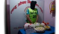 नेपाल प्रहरीको लागु औषध नियन्त्रण ब्यूरोले जफत गरिएको कोकेनसहित सार्वजनिक गरेका एक आरोपित। उनको अनुहार ढाक्ने गरी कालो मकुन्डो लगाइएको छ