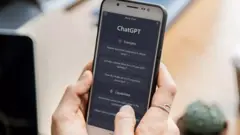 يد تمسك هاتفًا يظهر فيه تطبيق "تشات جي بي تي" أثناء محادثة.