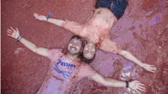 คนสองคนนอนบนพื้นที่เต็มไปด้วยน้ำมะเขือเทศ