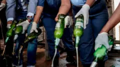South African Police Service (SAPS) officers destroy some 2000 litres of illegal alcohol confiscated during various operations, at Tshwane, on October 30, 2020.