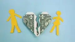 Casal de papel e coração feito de nota de 1 dólar rompido