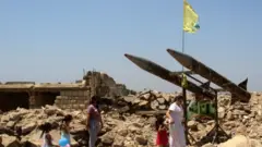 نساء وأطفال يزورون أنقاض مركز اعتقال الخيام في القرية التي تحمل الاسم نفسه على الحدود مع إسرائيل، في 7 أغسطس 2021