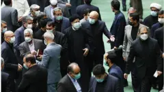 ابراهیم رئیسی رئیس جمهور ایران در صحن علنی مجلس. محمدباقر قالیباف به استقبال از آقای رئیسی از جایگاه هیات رئیسه پایین آمده است