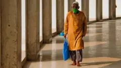বায়তুল মোকাররমে নামাজ পড়তে এসেছেন একজন মুসল্লি। মুখে মাস্ক।