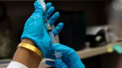 a syringe being prepared for a vaccination