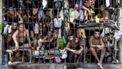 Inmates look out of an overcrowded cell in the Penal Center of Quezaltepeque, El Salvador. 9 November, 2018