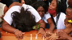 People cry during a funeral for five minors who were found dead in a sugar cane field, in Cali, Colombia August 14, 2020.