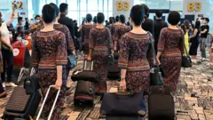 新加坡樟宜機場一群機組人員走向登機閘口上機執勤（資料圖片）