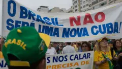 Manifestantes brasileiros com cartaz crítico a Cuba