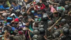 Guatemalan soldiers and police beat a group of Honduran migrants, in a road near to Chiquimula, Guatemala