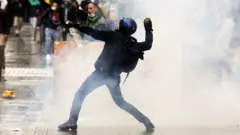 Un manifestante lanza una piedra durante las protestas de Colombia.