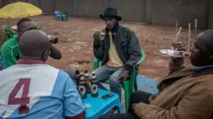 Des hommes en train de boire de la bière dans un bar du camp de réfugiés de Nakivale, dans le sud-ouest de l'Ouganda.