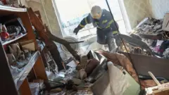 Des pompiers ukrainiens arrivent pour secourir des civils après qu'une frappe aérienne ait touché un complexe d'appartements à Chuhuiv, dans l'Oblast de Kharkiv, en Ukraine, le 24 février 2022.