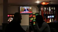 pubda oturan iki kişi