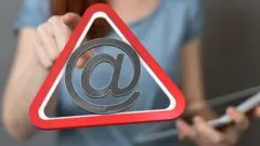 Símbolo de arroba con señal de advertencia.