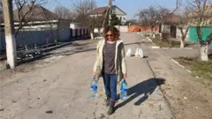 Silvana carrega garrafas com água