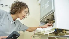 Female engineer inspecting a boiler