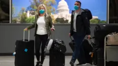Passengers arrive at Dulles International Airport in Virginia on 17 March 2020