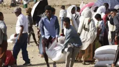 በትግራይ ሰዎች በአሜሪካ ተራድኦ ድርጅት የሚካፋፈል የእርዳ ምግብ ሲወስዱ