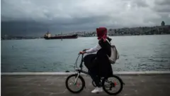 boğaz'da bisiklete binen bir kadın