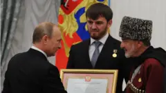 Президент России Владимир Путин, мэр Грозного Ислам Кадыров и актер Дагун Омаев на церемонии вручения сертификата о присвоении чеченской столице звания «Город воинской славы» в Кремле