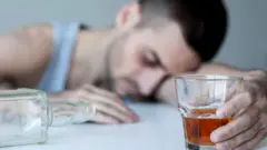 Пьяный человек со стаканом в руке