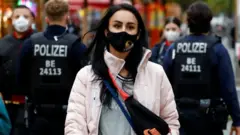 Police officers check the people wearing face masks at Wilmersdorfer Strasse shopping street, as the coronavirus disease (COVID-19) outbreak continues, in Berlin, Germany, October 26, 2020