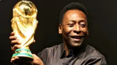 Pelé tenant une pièce de la Coupe du monde FIFA.