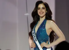Miss México usando um vestido azul com brilhos e posando com a mão na cintura