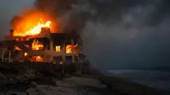 Casa em chamas de frente para o mar