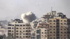 سحب الدخان والغبار متصاعدة جراء قصف إسرائيلي لأحد المباني في قطاع غزة