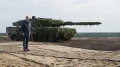 Olaf Scholz, Leopard 2 tanklarının önünde.