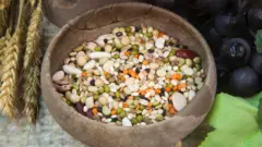 Bir yuvarlak ahşap kasenin içinde renkli tohumlar var