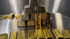 златне полуге наређане на сивом столу 