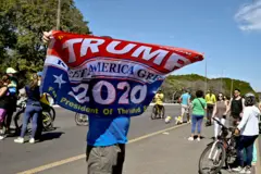 Apoiador de Bolsonaro com bandeira de campanha de Trump