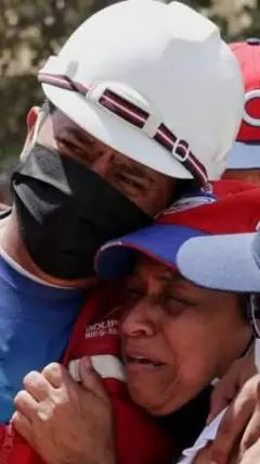 Dos personas lloran ante los escombros en Venezuela. 