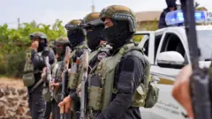 عناصر من قوى الأمن الداخلي يحملون أسلحة عند نقطة تفتيش تابعة لها تعمل على منع مقاتلين بدو من التقدم باتجاه السويداء، بعد تجدد القتال بين مقاتلين بدو ومسلحين دروز، على الرغم من وقف القتال في بلدة ولغا، محافظة السويداء، سوريا، 20 يوليو/تموز 2025. 
