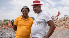 Wafanyakazi wa kujitolea Mzwandile Mkwayi (kulia) na Mandla Charles (kushoto) walilakiwa kama mashujaa baada ya kushuka kwenye shimo la kuchimba madini.