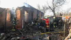 Спасиоци у униформама држе ватрогасна црева 