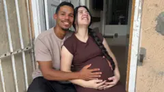 Vitor segurando a barriga de Ianka, que está grávida